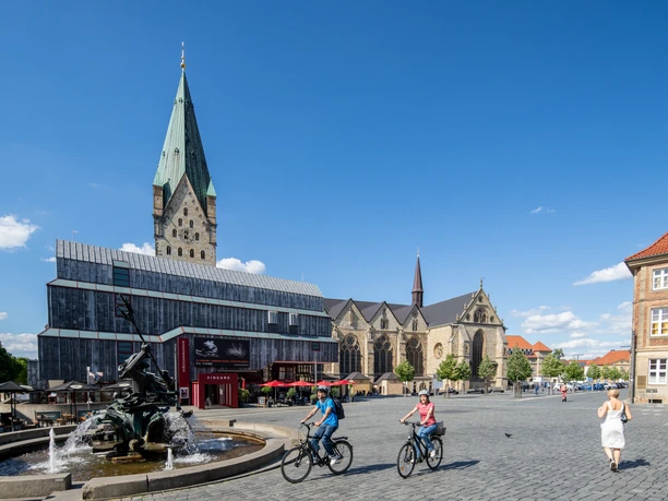 Paderborn-Dom-Teutoburger-Wald-Tourismus-Patrick-Gawandtka-076.jpg Der Marktplatz in Soest, Westfalen: Radfahrer vor dem Rathaus, Brunnen und der teils gotischen Kirche.