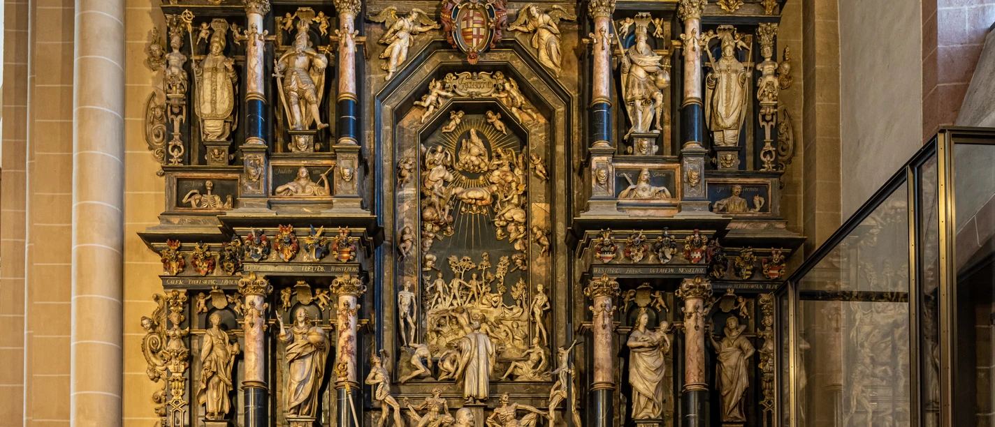 Ein kunstvoll verzierter, mehrstöckiger Altar mit zahlreichen religiösen Figuren in einer Kirche.