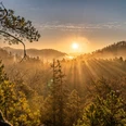 Blick vom Arnstein Sonnenaufgang über einem nebligen Wald mit strahlenden Sonnenstrahlen, die durch die Bäume scheinen; ruhige, goldene Atmosphäre.Sunrise over a misty forest with radiant sunbeams shining through the trees; calm, golden atmosphere.Východ slunce nad mlžným lesem, skrz stromy prosvítají zářivé sluneční paprsky; klidná, zlatavá atmosféra.Wschód słońca nad zamglonym lasem z promieniami słońca prześwitującymi przez drzewa; spokojna, złota atmosfera.Zonsopgang boven een mistig bos met stralende zonnestralen die door de bomen schijnen; kalme, gouden sfeer.Alba su una foresta nebbiosa con raggi di sole radiosi che brillano attraverso gli alberi; atmosfera calma e dorata.