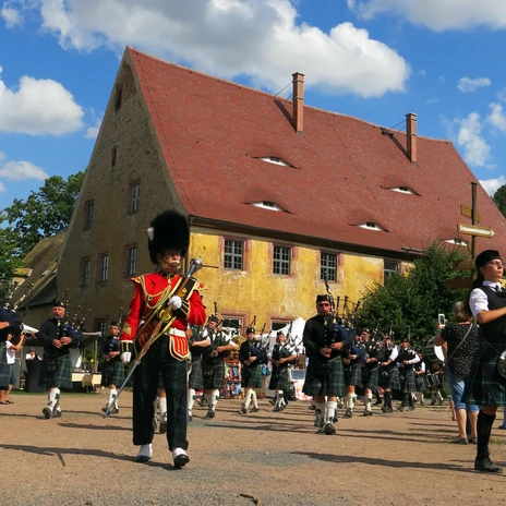 Music group with bagpipes and drums in front of Buch Monastery