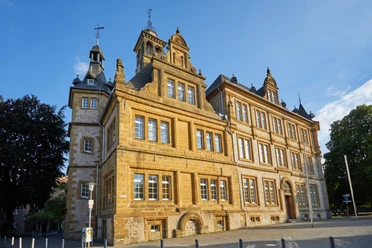 Historisches Gebäude in Bielefeld aus Sandstein mit Türmen und Ornamenten bei sonnigem Wetter.