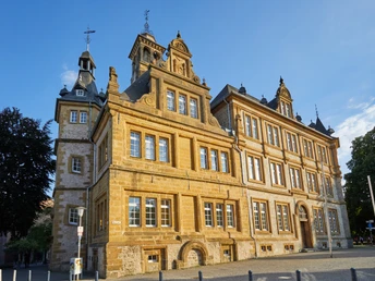 Historisches Gebäude in Bielefeld aus Sandstein mit Türmen und Ornamenten bei sonnigem Wetter.