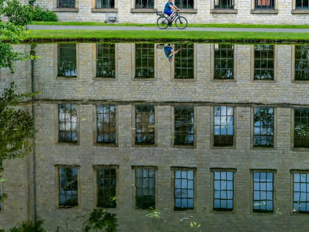 Bielefeld-RavensbergerPark-Teutoburger-Wald-Tourismus-Patrick-Gawandtka-089.jpg <p>Radfahrer vor historischer Steinmauer, spiegelnd in einem ruhigen Wasser.</p>