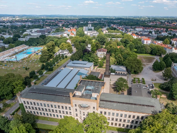 Bielefeld-RavensbergerPark-Teutoburger-Wald-Tourismus-Patrick-Gawandtka-090-CC-BY-SA.jpg Luftaufnahme eines historischen Gebäudes inmitten grüner Landschaft unter blauem Himmel mit Wolken.