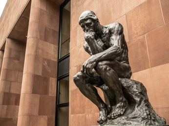 Bielefeld-Skulpturenpark Kunsthalle-Teutoburger-Wald-Tourismus-D-Ketz-031-CC-BY-SA.jpg Das Bild zeigt die Statue von Auguste Rodins "Der Denker" vor einem roten Sandsteingebäude.
