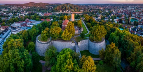 Bielefeld-Sparrenburg-Teutoburger-Wald-Tourismus-D-Ketz-009-CC-BY-SA.jpg Panoramablick auf die Sparrenburg in Bielefeld, umgeben von üppigem Grün und Stadtlandschaft.