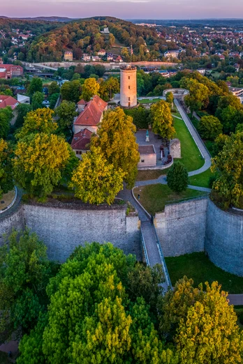 Bielefeld-Sparrenburg-Teutoburger-Wald-Tourismus-D-Ketz-009-CC-BY-SA.jpg Panoramablick auf die Sparrenburg in Bielefeld, umgeben von üppigem Grün und Stadtlandschaft.
