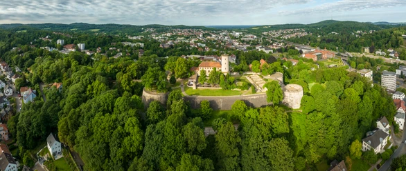 Bielefeld-Sparrenburg-Teutoburger-Wald-Tourismus-D-Ketz-010.jpg Burgruine auf bewaldetem Hügel, umgeben von Stadt und grüner Hügellandschaft.