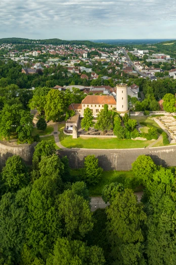Bielefeld-Sparrenburg-Teutoburger-Wald-Tourismus-D-Ketz-010.jpg Burgruine auf bewaldetem Hügel, umgeben von Stadt und grüner Hügellandschaft.