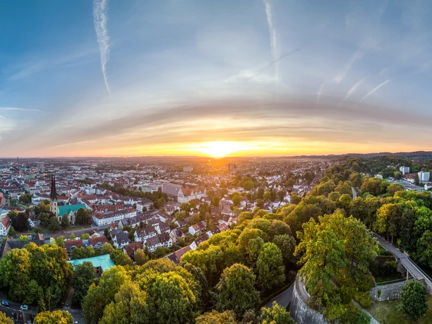 Bielefeld-Sparrenburg-Teutoburger-Wald-Tourismus-D-Ketz-013.jpg Panorama von Bielefeld bei Sonnenuntergang, mit grünen Hügeln und der Stadt im Tal eingebettet.