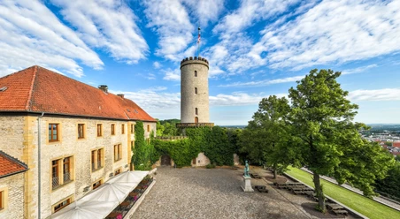 Bielefeld-Sparrenburg-Teutoburger-Wald-Tourismus-D-Ketz-013-CC-BY-SA.jpg Turm der Sparrenburg in Bielefeld mit historischem Gebäude und begrüntem Innenhof im Vordergrund.