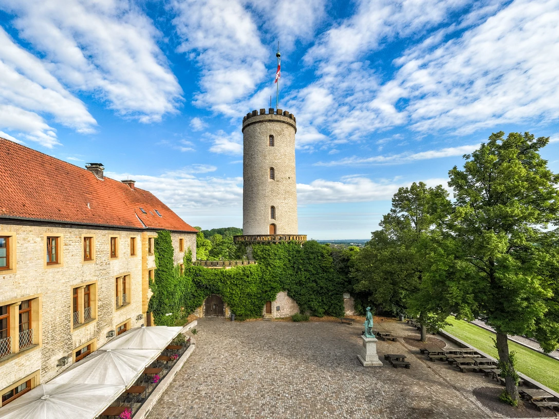 Bielefeld-Sparrenburg-Teutoburger-Wald-Tourismus-D-Ketz-013-CC-BY-SA.jpg Turm der Sparrenburg in Bielefeld mit historischem Gebäude und begrüntem Innenhof im Vordergrund.