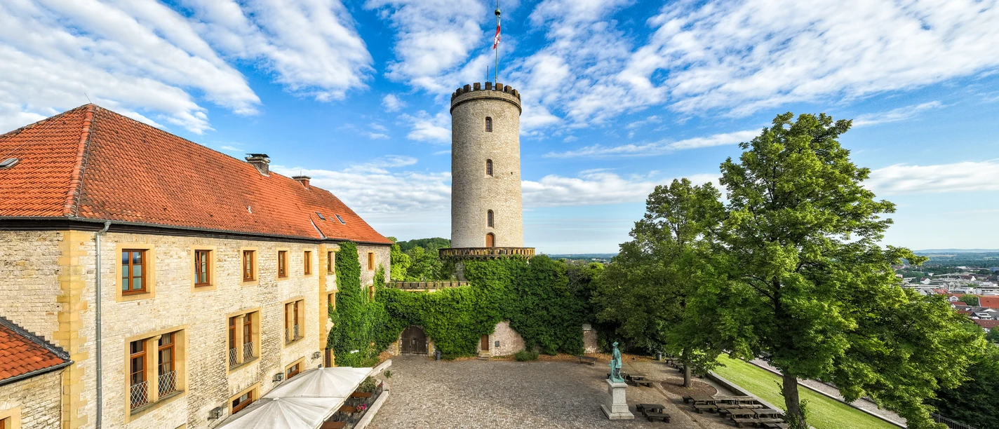 Bielefeld-Sparrenburg-Teutoburger-Wald-Tourismus-D-Ketz-013-CC-BY-SA.jpg Turm der Sparrenburg in Bielefeld mit historischem Gebäude und begrüntem Innenhof im Vordergrund.
