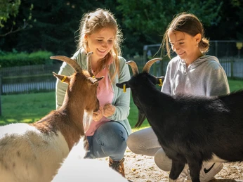 Bielefeld-Tierpark Olderdissen-Teutoburger-Wald-Tourismus-D-Ketz-016.jpg <p>Zwei Mädchen füttern Ziegen auf einem hellen, sonnigen Bauernhof. Freude und Natur vereint.</p>
