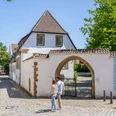 Bielefeld-Welle-Teutoburger-Wald-Tourismus-Patrick-Gawandtka-057.jpg <p>Pärchen spaziert auf gepflasterter Gasse zu historischem Torbogen in sonniger Altstadt.</p>