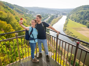 Beverungen-Weser Skywalk-Teutoburger-Wald-Tourismus-D-Ketz-020.jpg <p>Paar auf Aussichtsplattform fotografiert sich vor grünem Tal, Fluss und bewaldeten Hügeln.</p><p>Paar op uitkijkplatform gefotografeerd voor groene vallei, rivier en beboste heuvels.</p> <p<p>Couple on viewing platform photographed in front of green valley, river and wooded hills.</p> <p