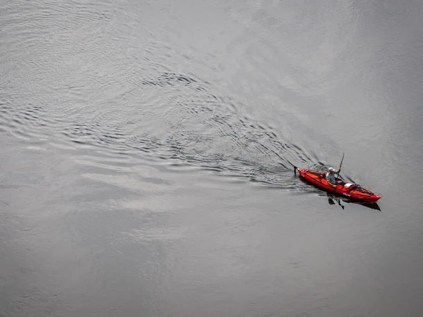 Beverungen-Weser Skywalk-Teutoburger-Wald-Tourismus-D-Ketz-021.jpg A red kayak with two people paddling on a calm river, seen from above.