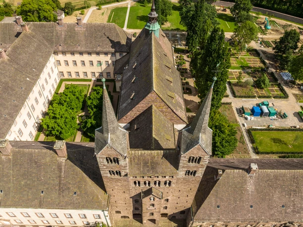 Luftaufnahme eines historischen Gebäudekomplexes mit hohem, spitzem Dach und mehreren Türmen.