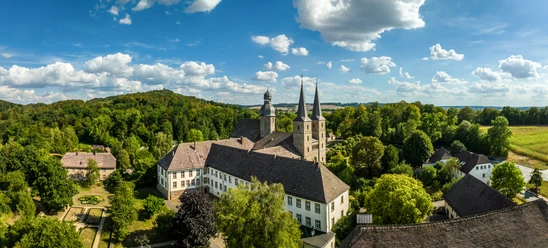 Marienmuenster-Abtei Marienmuenster-Teutoburger-Wald-Tourismus-D-Ketz-075.jpg Luftaufnahme eines historischen Klosters im Grünen, umgeben von dichten Wäldern und Hügeln.