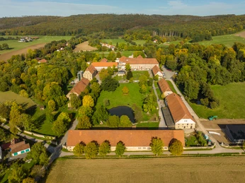 Warburg-Kloster Hardehausen-Teutoburger-Wald-Tourismus-D-Ketz-053-CC-BY-SA.jpg Luftaufnahme eines historischen Gutshofes, umgeben von grünen Feldern und dichten Wäldern.