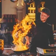 Restaurant Pferdestall im Gräflichen Park Mann brät im Restaurant Pferdestall das Essen, Feuer kommt aus der Pfanne raus.