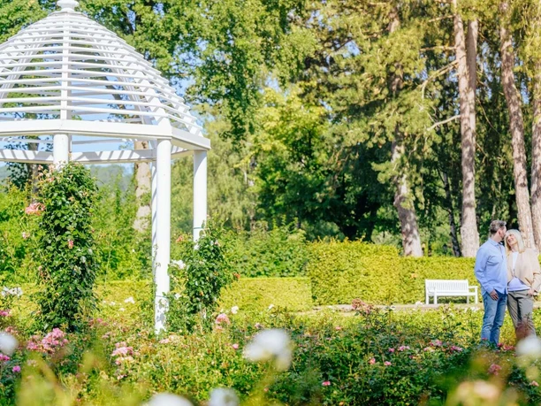 Rosengarten im Gräflichen Park, mit einem Monopteros und sich anguckenden Paar.