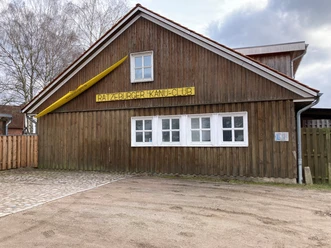 Ratzeburger_KanuClub_PetraRoemer_032023.jpg Ratzeburger Kanu Club, Gebäude mit Holzverkleidung und gelber Schrift