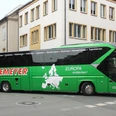 Grüner Reisebus von Aschemeyer mit europäischer Landkarte und Slogan auf der Seitenfläche.