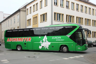 Ausflugsfahrt Aschemeyer Grüner Reisebus von Aschemeyer mit europäischer Landkarte und Slogan auf der Seitenfläche.