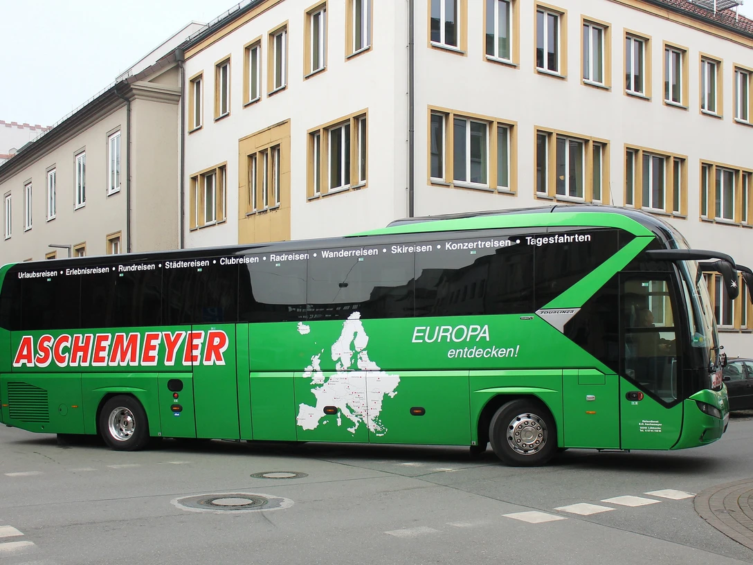 Ausflugsfahrt Aschemeyer Grüner Reisebus von Aschemeyer mit europäischer Landkarte und Slogan auf der Seitenfläche.