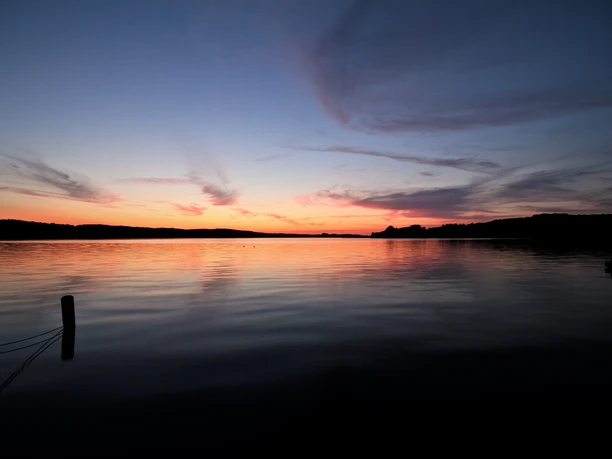 Ratzeburger See bei buntem Sonnenuntergang.jpg Der Ratzeburger See bei Sonnenuntergang. Der Himmel ist bunt gefärbt.