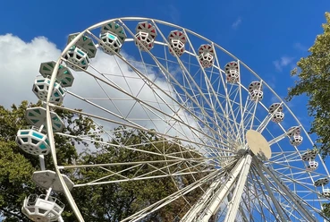 Domweih Verden Weißes Riesenrad in Verden vor blauem Himmel und Bäumen, fängt den fröhlichen Festcharakter ein.