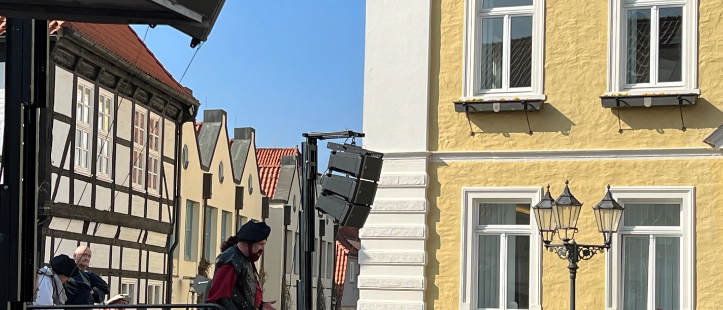 Läthare Spende Verden A speaker dressed in medieval garb addresses a crowd against the historic backdrop of Verden.