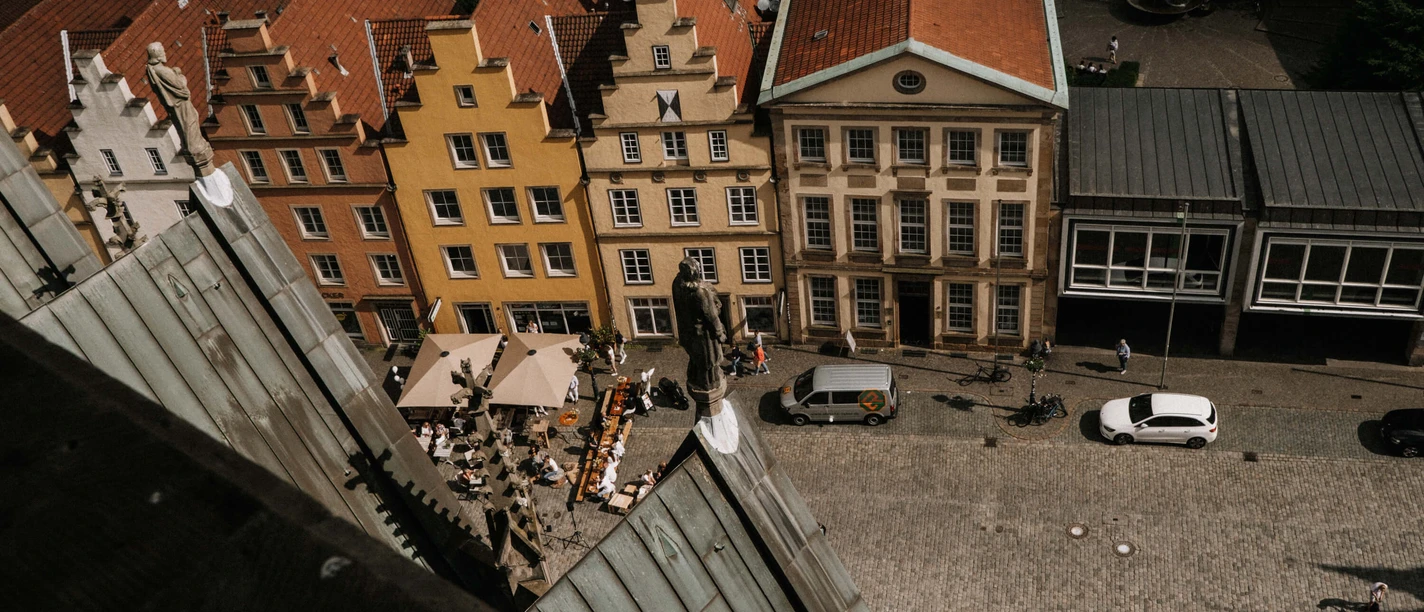 Luftansicht des EMR von der Marienkirche aus gesehen Blick auf den Platz mit farbenfrohen Giebelhäusern und Cafétischen aus der Höhe der Marienkirche.