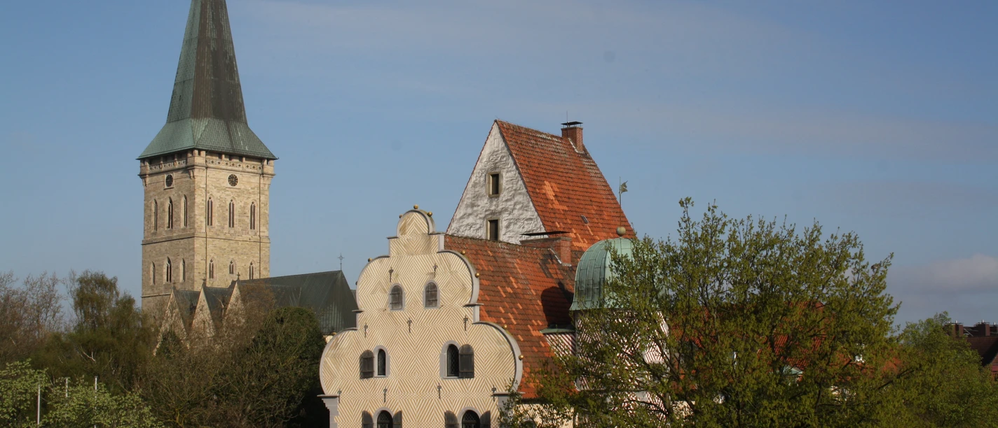 In 2002, the German Foundation for Peace Research moved into the ground floor of the Ledenhof. Ledenhof Palais in Osnabrück mit eindrucksvoller Fassade, umgeben von grünen Bäumen und historischem Turm.
