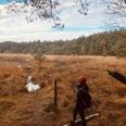Eine Wanderin blickt in die Weite des herbstlichen Heilsmoores.A hiker gazes into the expanse of the autumnal Heilsmoor.En vandrer kigger ud over det efterårsagtige Heilsmoor.Een wandelaar kijkt uit over de uitgestrektheid van de herfstige Heilsmoor.