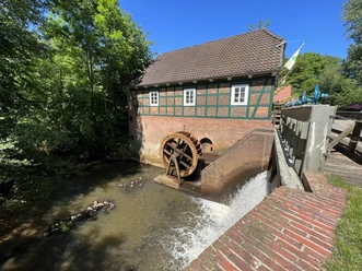 Wassermühle Meyenburg Mill wheel of the Meyenburg watermill with stream and mill building.