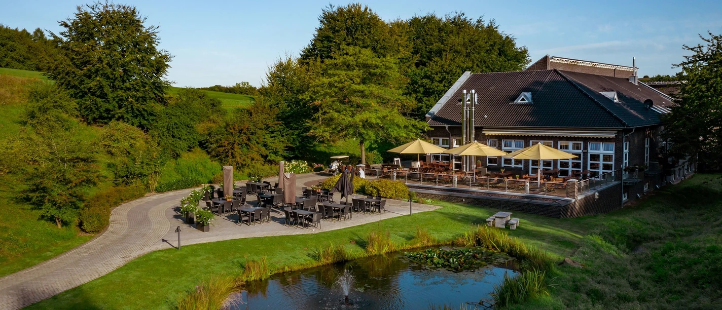 Landhaus Grevenmühle in Ratingen Landhaus Grevenmühle in Ratingen mit großer Terrasse, umgeben von Grünflächen und Teichanlage.