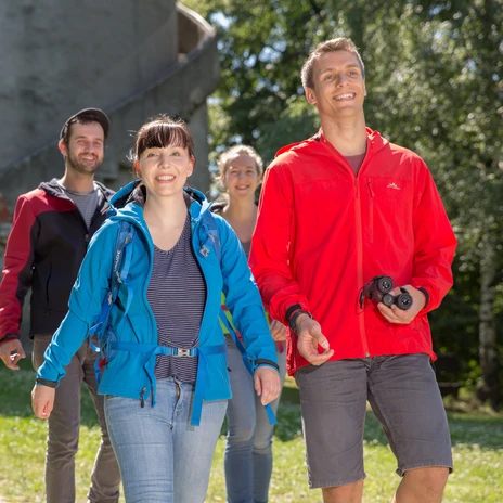 Four friends in front of the Albert Tower in Collm in Wermsdorf, smiling