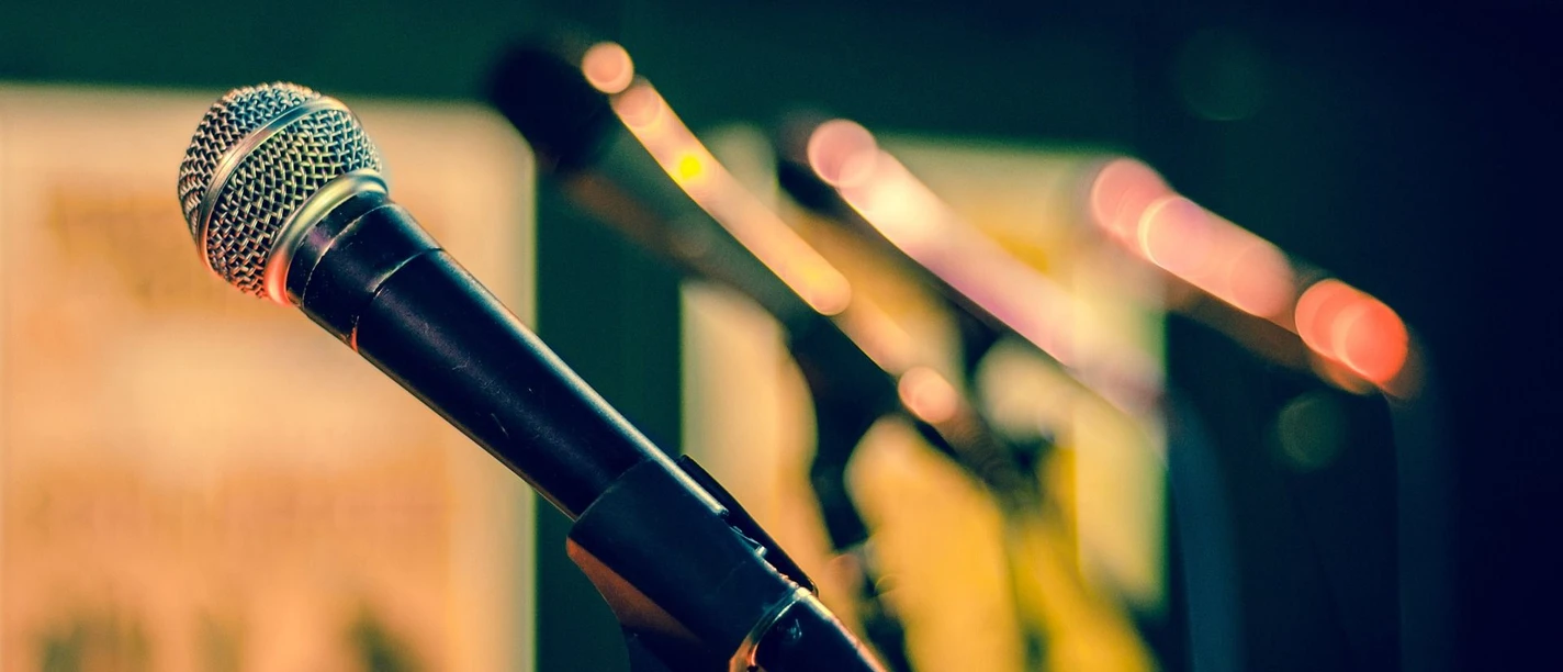 Konzert Mikrophone stehen in Halterungen nebeneinander.
