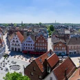 Panorama des belebten Marktplatzes in Rheine mit historischen Gebäuden und Menschen im Freien.