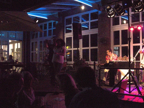 Druckerei Outdoor Musiker in stimmungsvoller Beleuchtung treten vor Publikum in einem städtischen Innenhof auf.