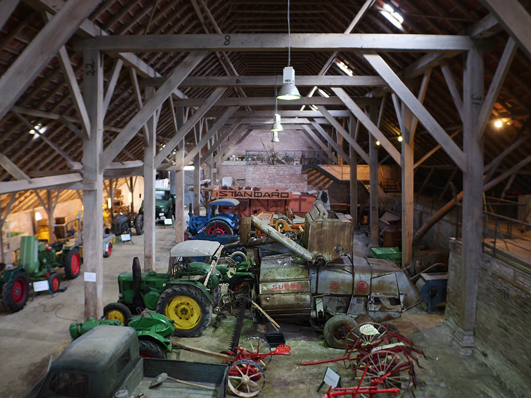 Ostfriesisches Landwirtschaftsmuseum Campen Blick in die Scheune des Museums mit den historischen Treckern und Fahrzeugen. View of the museum's barn with the historic tractors and vehicles. Udsigt over museets lade med de historiske traktorer og køretøjer. Kijk in de schuur van het museum met de historische tractoren en voertuigen.
