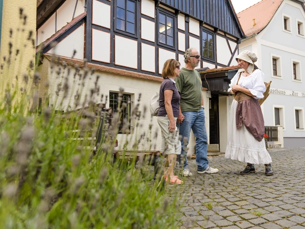 Museum Wassermühle in Höfgen - Erlebnisse in der Region Leipzig Ein Paar und eine Frau in Tracht am Museum Wassermühle in Grimma in der region Leipzig