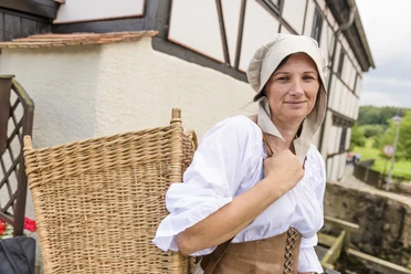 Gasthaus am Museum Wassermühle in Grimma - Geschichte in der Region Leipzig Vrouw in klederdracht met rieten mand in de herberg Museum Wassermühle in Grimma in de regio Leipzig
