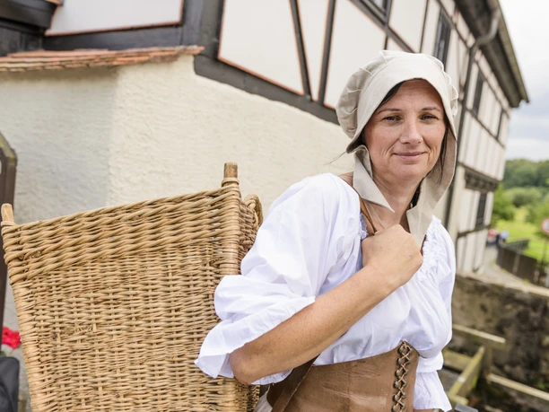 Gasthaus am Museum Wassermühle in Grimma - Geschichte in der Region Leipzig Frau in Tracht mit Weidenkorb am Gasthaus Museum Wassermühle in Grimma in der Region Leipzig