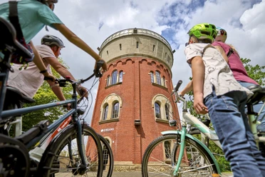 Camera Obscura, Mülheim an der Ruhr Eine vierköpfige Familie mit Fahrrädern betrachtet den Broicher Wasserturm mit der Camera Obscura bei einer Fahrradtour.