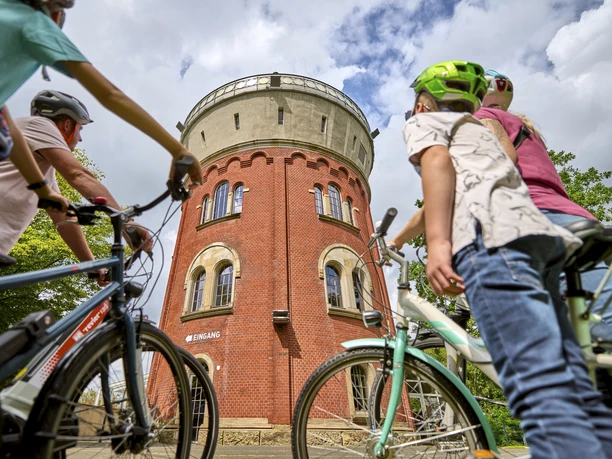 Camera Obscura, Mülheim an der Ruhr Eine vierköpfige Familie mit Fahrrädern betrachtet den Broicher Wasserturm mit der Camera Obscura bei einer Fahrradtour.