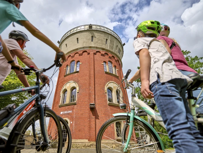 Camera Obscura, Mülheim an der Ruhr Eine vierköpfige Familie mit Fahrrädern betrachtet den Broicher Wasserturm mit der Camera Obscura bei einer Fahrradtour.