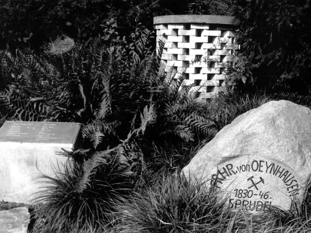 Oeynhausen-Sprudel, Rotunde um 1995 Stein mit Inschrift "Oeynhausen-Sprudel" und Gedenkstein in einer von Farnen umgebenen Parkanlage.